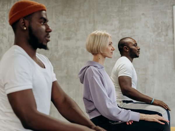 A group of athletes meditating together in a calm environment.